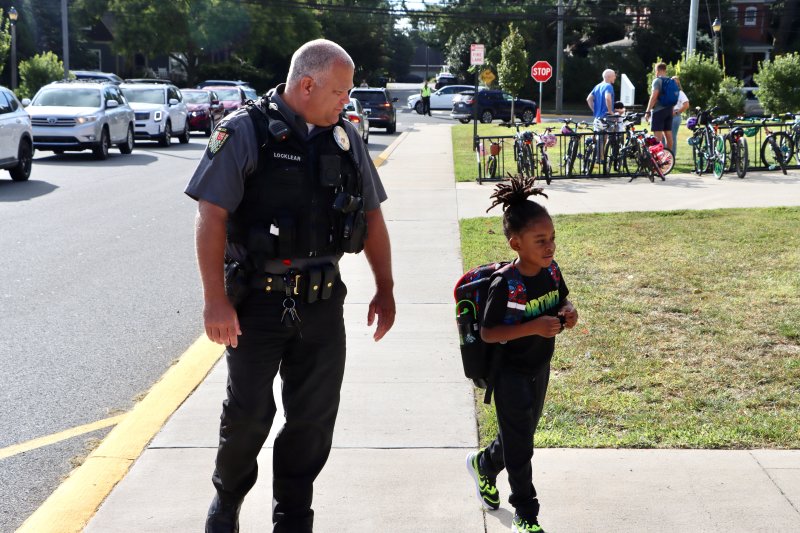 Lewes Deputy Police Chief Jamie Locklear walks with a student as she heads for the first day of school. BILL SHULL PHOTO